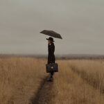 Person standing in the rain in a gloomy setting