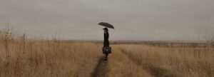 Person standing in the rain in a gloomy setting